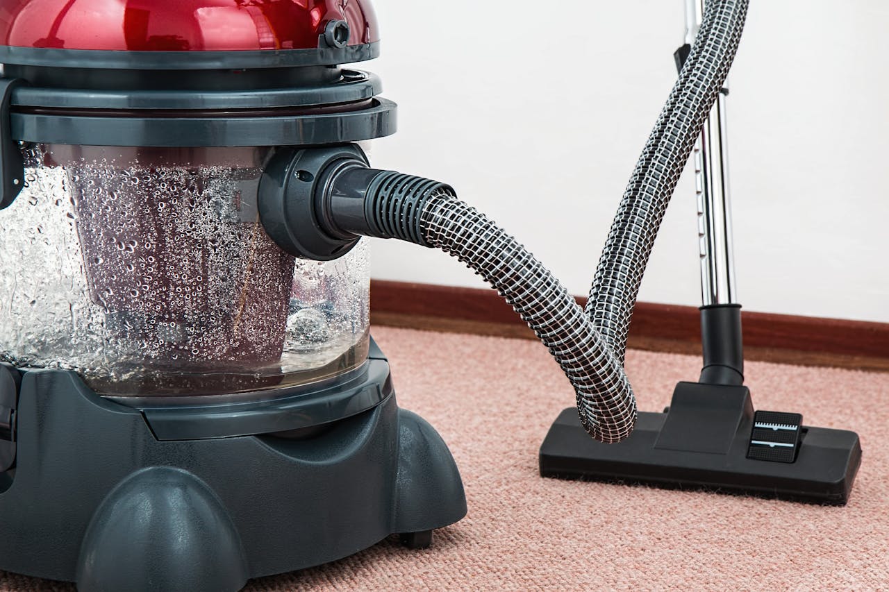 portfolio-02 Close-up of a modern vacuum cleaner with water filtration on carpet floor indoors.